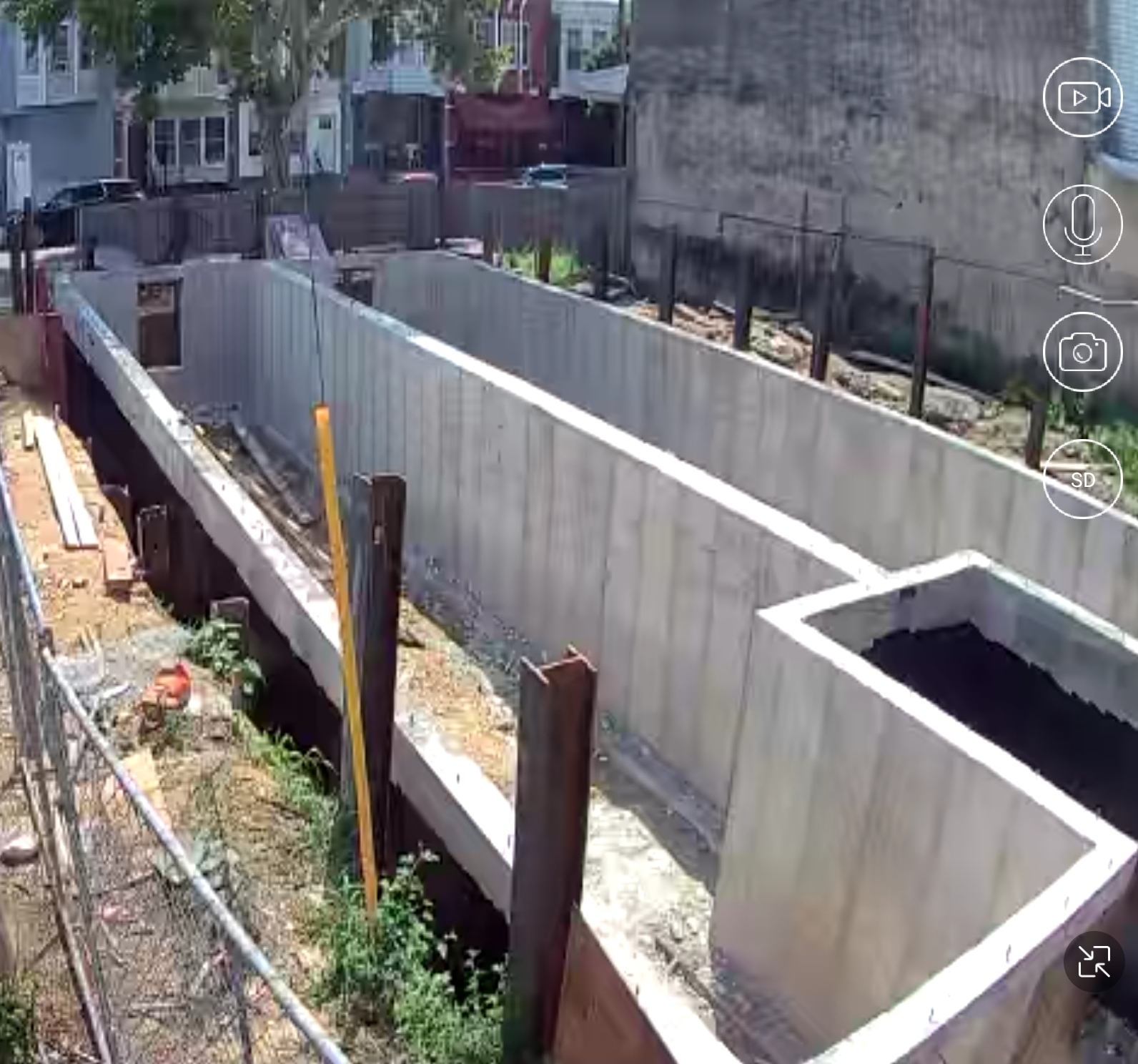 Construction site with freshly poured concrete foundation walls and steel beams for a North Philadelphia duplex
