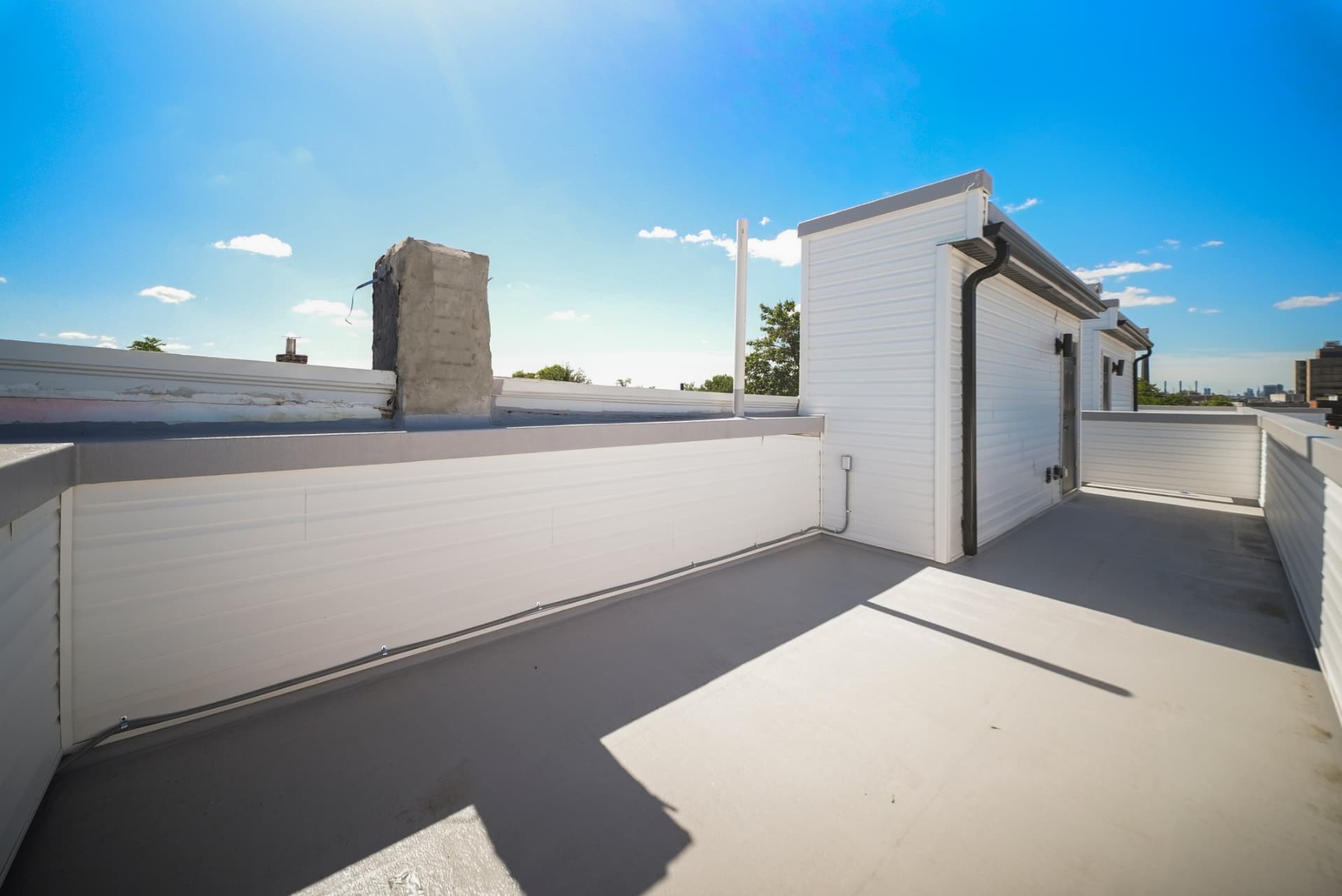 Private rooftop deck with privacy walls under a clear blue sky