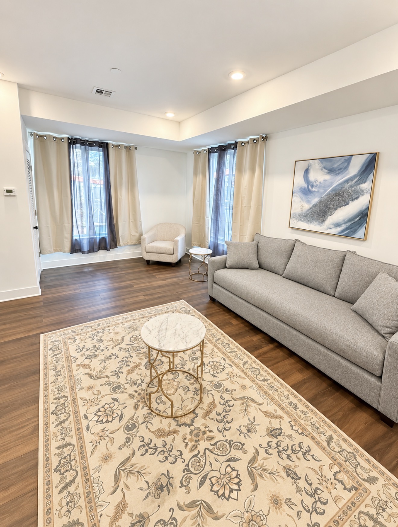 Living room with grey sofa, abstract art and marble coffee table
