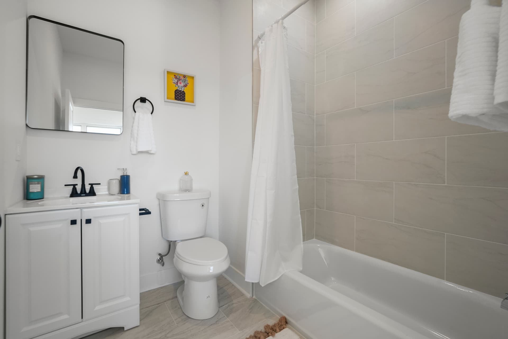 Second full bathroom with marble-look tile, vanity and soaking tub