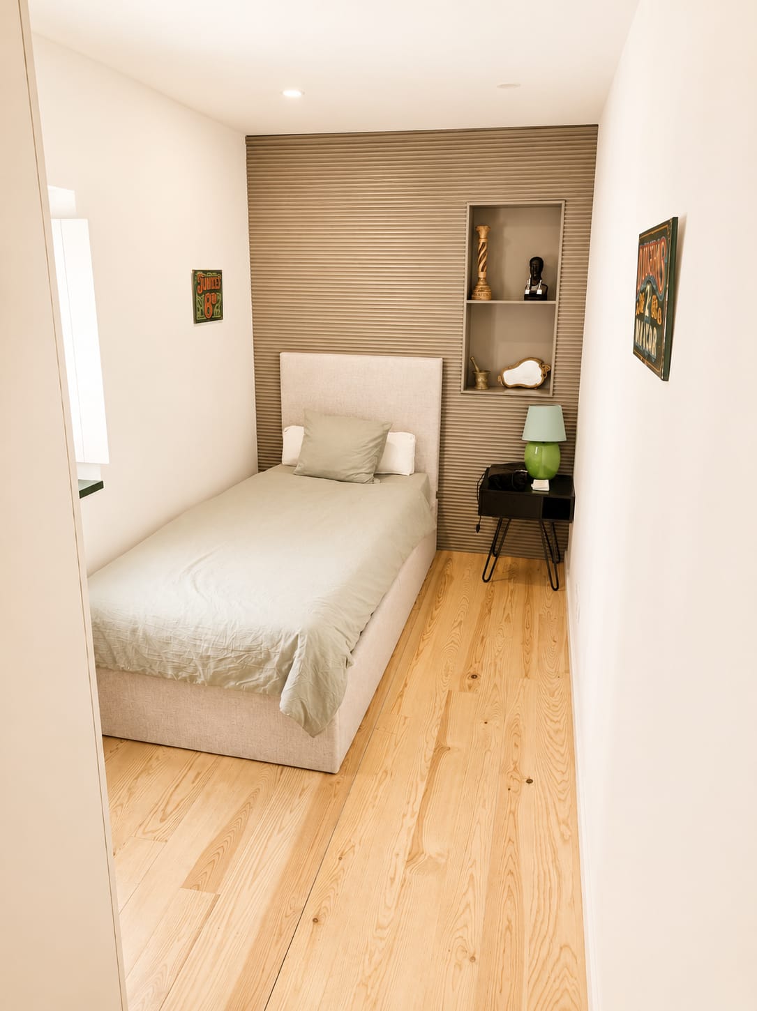 Second bedroom with single bed, linen headboard and vintage painted signs